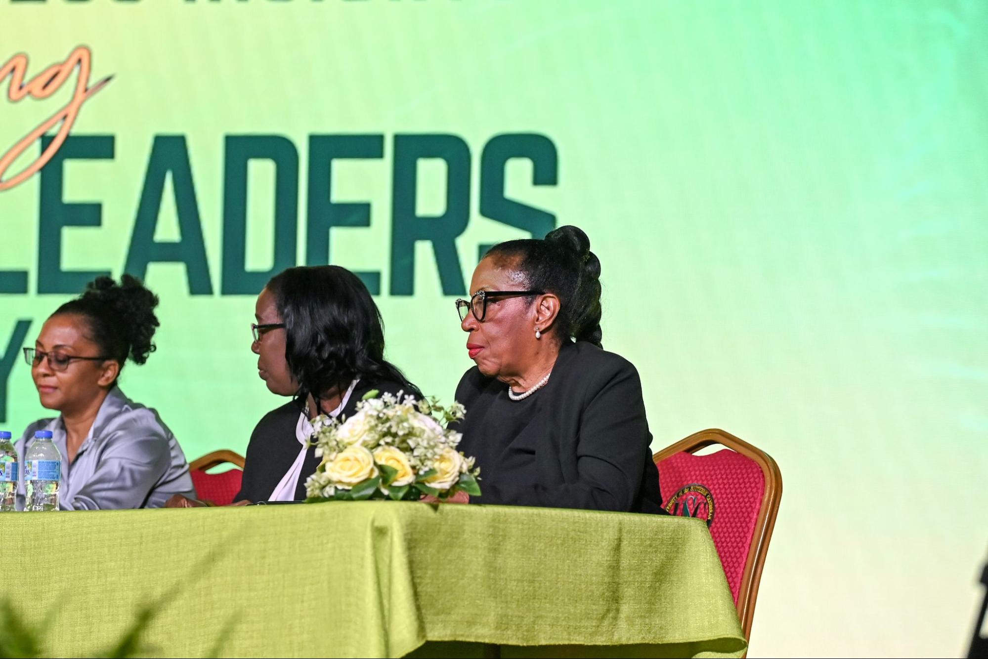 Two female industry professionals sit at a panel table during the USC Business Seminar Day, with the word "LEADERS" in the background