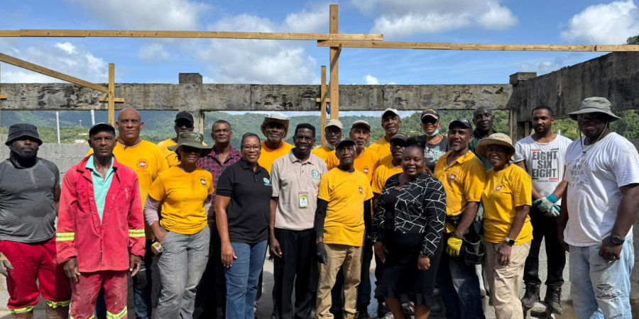Group of international volunteers and USC staff standing inside the unfinished Ladies Residence Hall