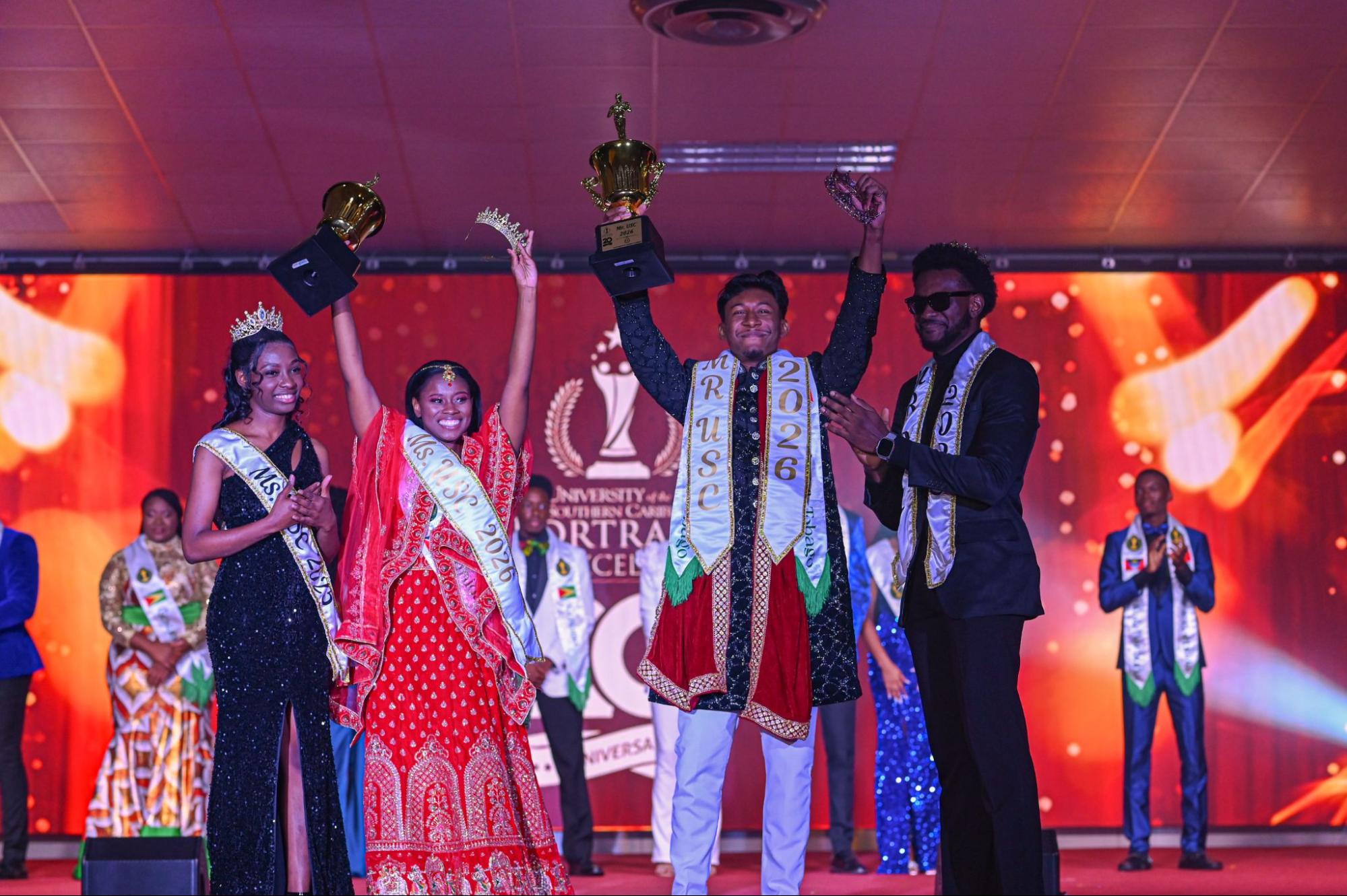 Newly crowned Ms and Mr USC 2026, Mya Garraway and Nicholas Hanooman, joyfully hold up their trophies and crowns on stage, standing next to the outgoing titleholders.