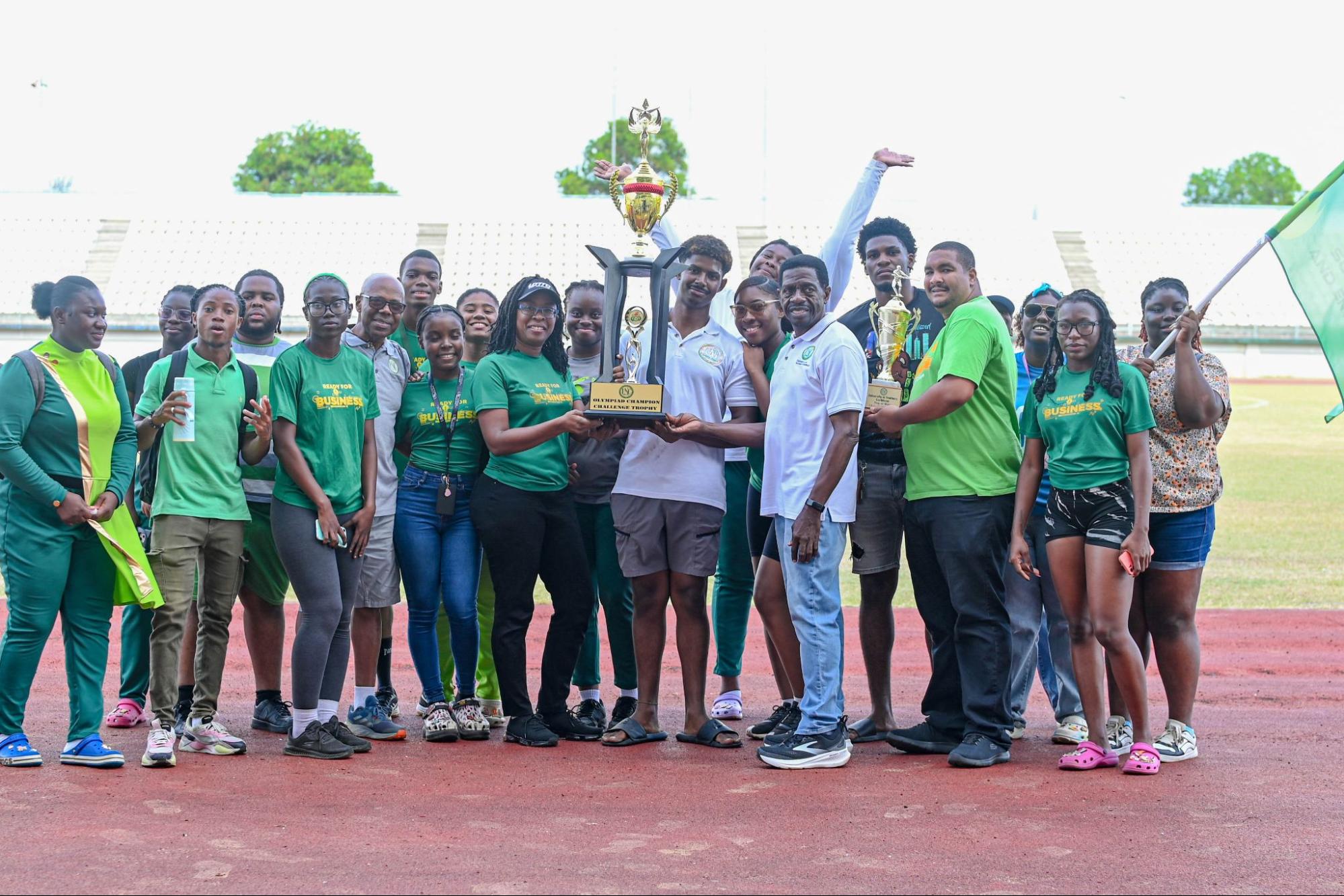 A large group from the School of Business and Entrepreneurship holding a tall gold trophy