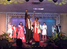 Michael Garcia (Mr. USC) and Alicia Lewis (Ms. USC )standing centre stage as the crowned winners of the USC 2025 pageant, wearing sashes and smiling while fellow contestants applaud.